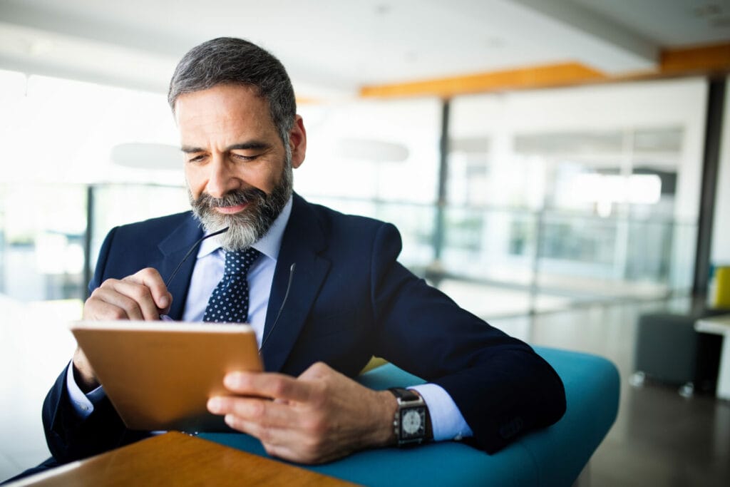 C-level businessman reviewing QSBS information on a tablet 