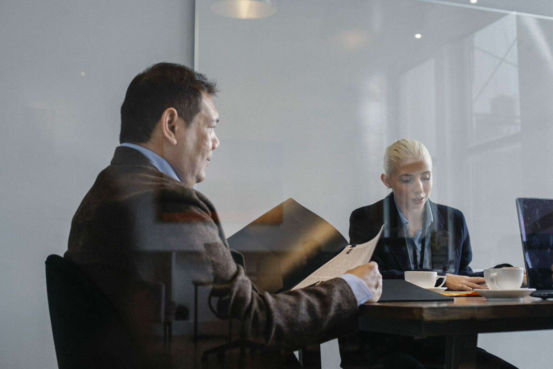 Two colleagues in a conference room looking over QSBS reports